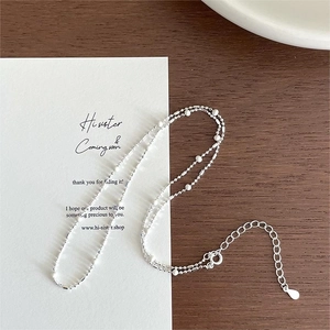 Macro detail of 925 sterling silver necklace with white beads and adjustable extension chain