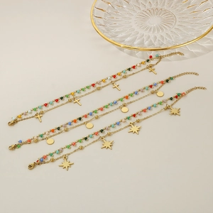 Detailed view of gold multi-layered bracelets with cross, star, and round pendants