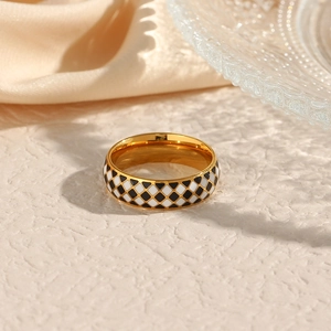 Detail view of 18K gold plated ring with black and white checkered enamel pattern