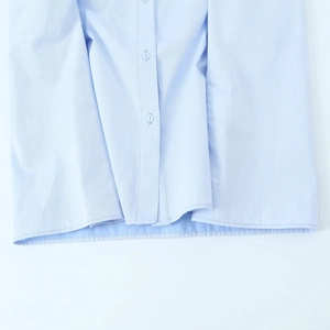 Damen Oxford-Hemd in Hellblau mit Knopfdetails und sauberen Saum auf weißem Grund