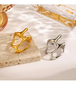 Detailed close-up of irregular fluid style gold and silver rings on stone surface