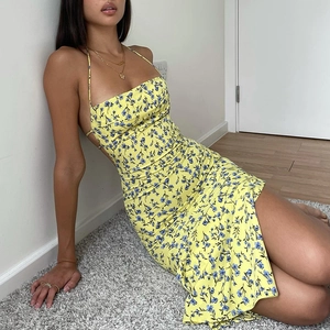 Detailed view of yellow floral spaghetti strap dress with high side slit and open back