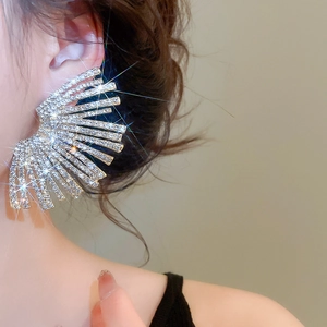 Macro shot of large fan-shaped earring with brilliant rhinestones on model's ear