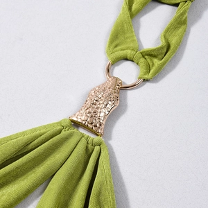 Détail du tissu en maille verte avec boucle en métal or rose à texture crocodile