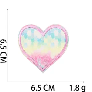 Macro view of gradient sequin heart patch measuring 6.5cm with pink embroidery edge
