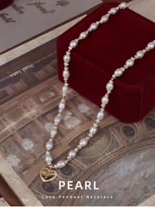 Detail of natural freshwater pearl necklace with heart pendant on red velvet jewelry box