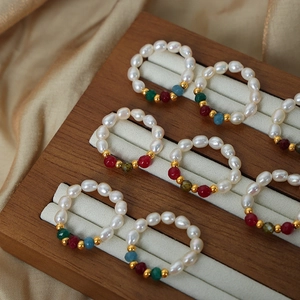 Handmade freshwater pearl rings with colorful gemstones on a luxury jewelry display tray