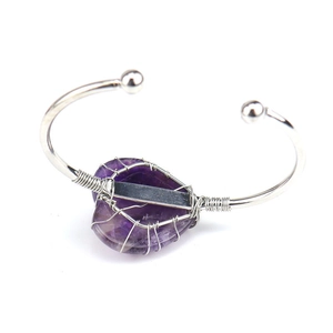 Detailed shot of handmade silver wire wrapped purple amethyst crystal on open bangle