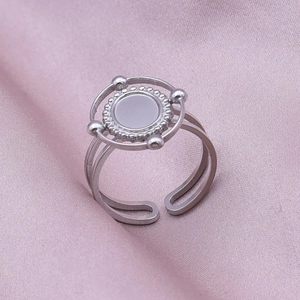 Macro shot of silver geometric oval adjustable ring on soft lavender satin fabric