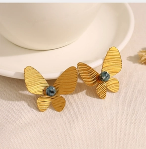Detailed macro of vintage 18K gold butterfly earrings with African turquoise stones