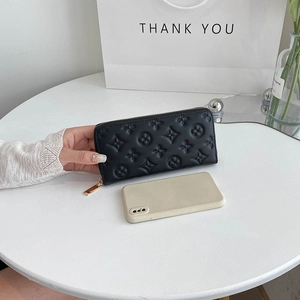 Detailed view of black embossed leather wallet with gold zipper and multi-card slots