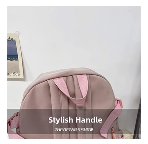 Close-up of durable reinforced handle on a minimalist pink school backpack with neat stitching