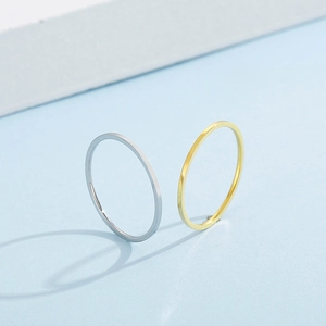 Detailed view of two minimalist slim stackable stainless steel rings in gold and silver finish