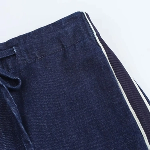 Dettagli del tessuto denim blu scuro con strisce laterali bianche e coulisse in vita