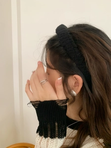 Close-up of a black plush headband worn with silver ring and matching earrings