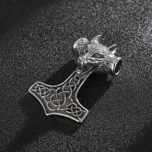Detail of Thor's hammer Mjolnir pendant with wolf head and Celtic knot carvings