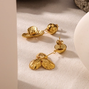 Elegant gold-tone 3D floral stud earrings crafted in stainless steel on textured fabric