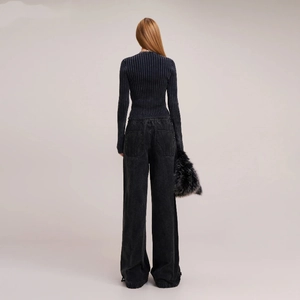 Rear view of a slim rib-knit cardigan and high-waist washed denim jeans in a chic look