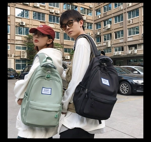 Outdoor shot of teenagers wearing light green and black large capacity nylon backpacks
