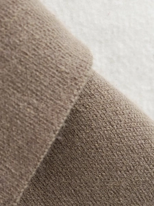 Detailed macro view of the soft brown knit fabric texture and premium fiber quality