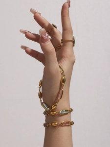 Detail eines 18k vergoldeten Armbands mit facettierten rosa, blauen und grünen Steinen