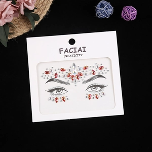 Detailed view of red and clear crystal face jewels on eye makeup template card
