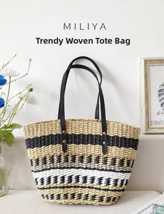 Detail of a handmade straw tote bag with color block stripes and black leather handles