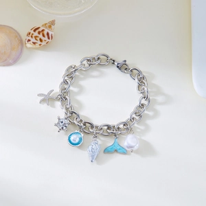 Close-up of ocean-themed silver charm bracelet with starfish, shell, and pearl details
