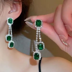 Elegante Ohrringe mit smaragdgrünen Edelsteinen und funkelnden Kristallakzenten