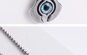 Macro detail of silver stainless steel evil eye pendant with blue resin and ball chain