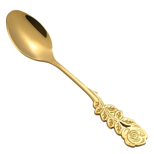 Golden stainless steel spoon with rose and leaf embossed handle on a white background
