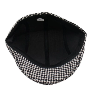 Detail view of the black and white houndstooth flat cap featuring a breathable inner lining