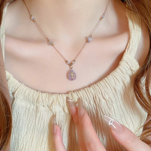 Détail du collier de perles en pierre avec pendentif cristal violet et croix dorée