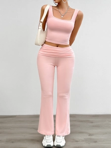 Detail of pink knitted crop top and high-waist flared pants set with pleated waistband