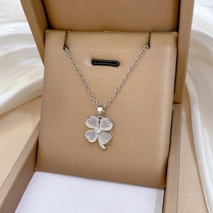 Close-up of cat eye clover necklace with crystals in a premium jewelry gift box