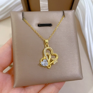 Vue détaillée du collier pendentif double cœur avec cristaux brillants dorés