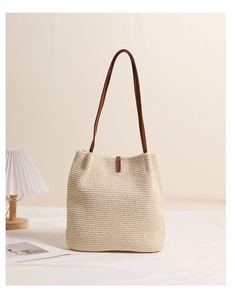 Detail of hand-woven cotton shoulder bag with wooden beads and brown leather straps