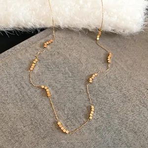 Minimalist adjustable gold beaded necklace with square cubes for a modern look