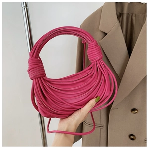 Dettaglio della borsa a mano intrecciata rosa fucsia con manico in corda di pelle
