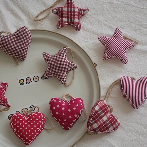 Detailed close-up of heart and star fabric Christmas ornaments with rustic jute rope ties