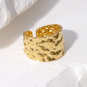 Macro detail of 18K gold plated wide band ring with irregular hammered texture on stone