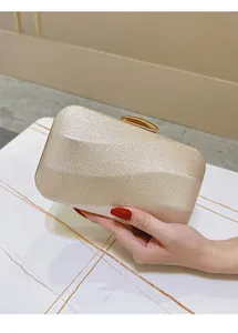 Detail of champagne gold evening clutch featuring geometric texture and metal clasp