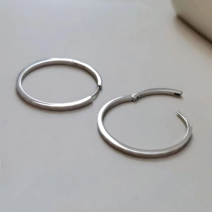 Close-up of S925 sterling silver hoop earrings with sparkly textured diamond-cut pattern