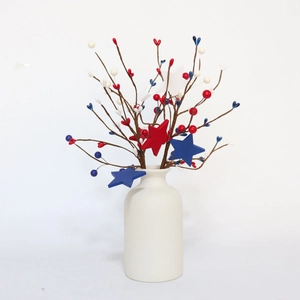 Red white and blue patriotic berry branch ornaments with stars in a white vase