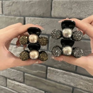 Detail of luxury acrylic hair claw clips with pearls and glitter bead accents