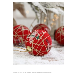 Macro shot of red cloth-wrapped Christmas ball with twine hanging string and warm bokeh