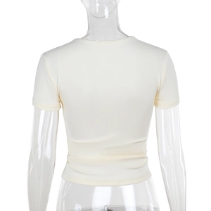 Détail du haut en maille blanc crème avec col en V et bordure en dentelle délicate