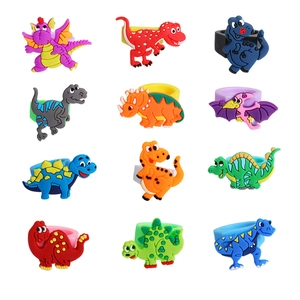 Colorful 12-piece set of cartoon dinosaur rings in a 3x4 grid for children's party favors