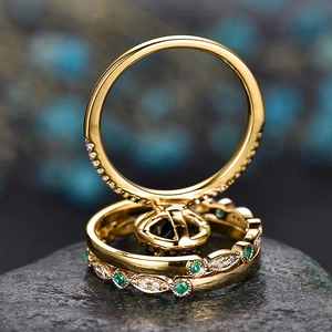 Detailed macro view of vintage gold ring set with green emerald and white zircons