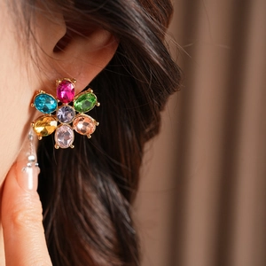 Close-up of vintage floral earrings with colorful crystals on a model for a luxury look